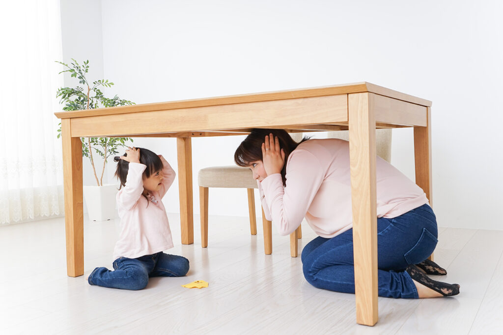 A parent and child huddling under a table